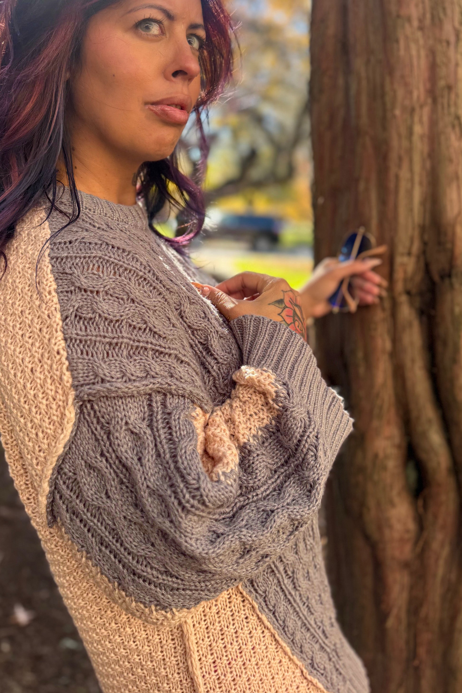 Woman wearing a textured cardigan with a blurred natural background